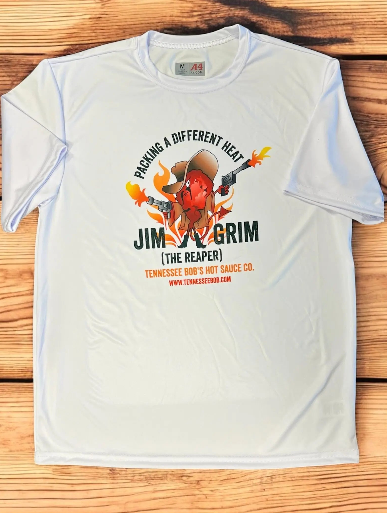 White t-shirt with a graphic design of a hot pepper and text on a wooden surface