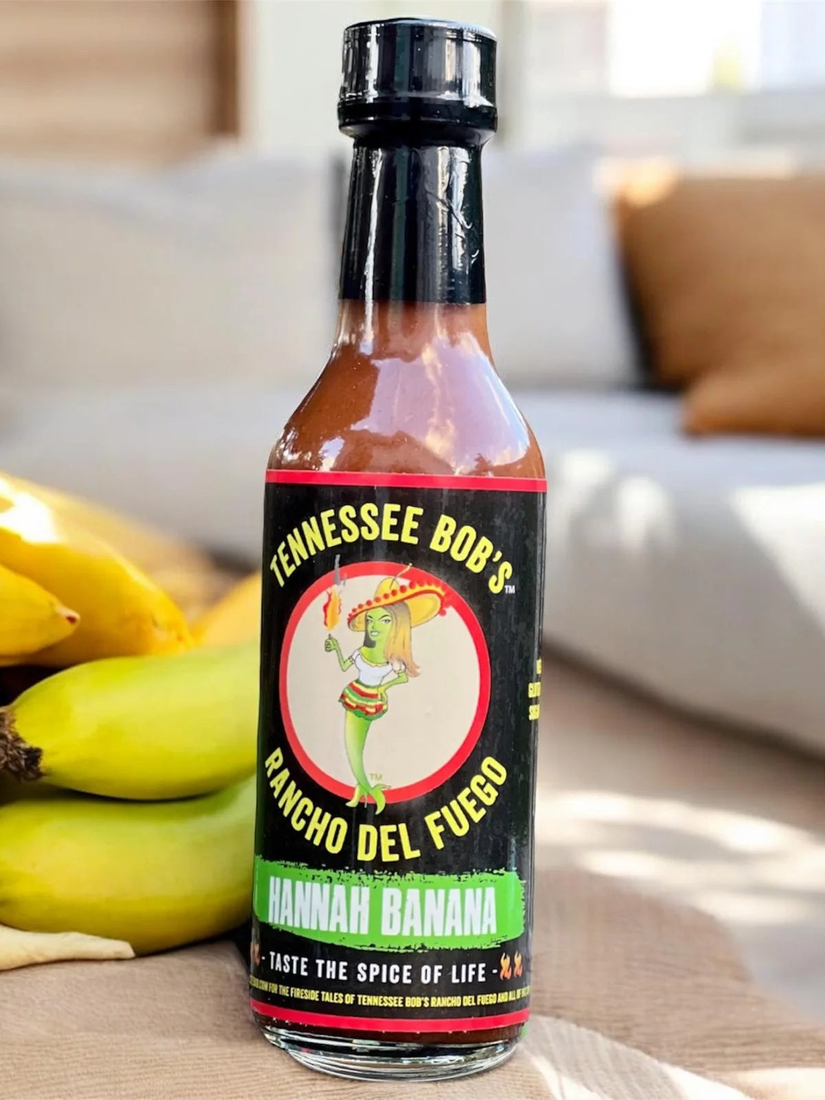 Bottle of Tennessee Bob's Hannah Banana hot sauce with bananas in the background