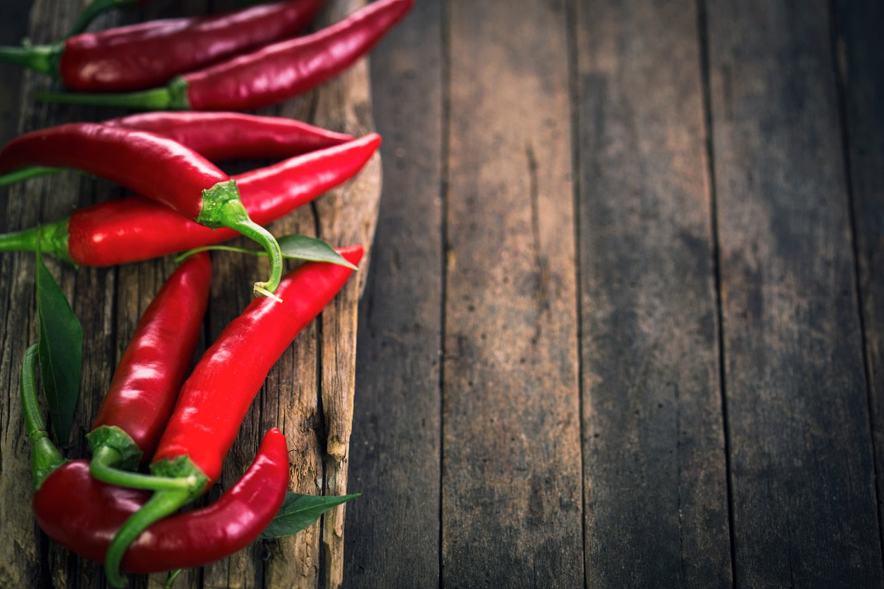 Red chili peppers on a wooden surface
