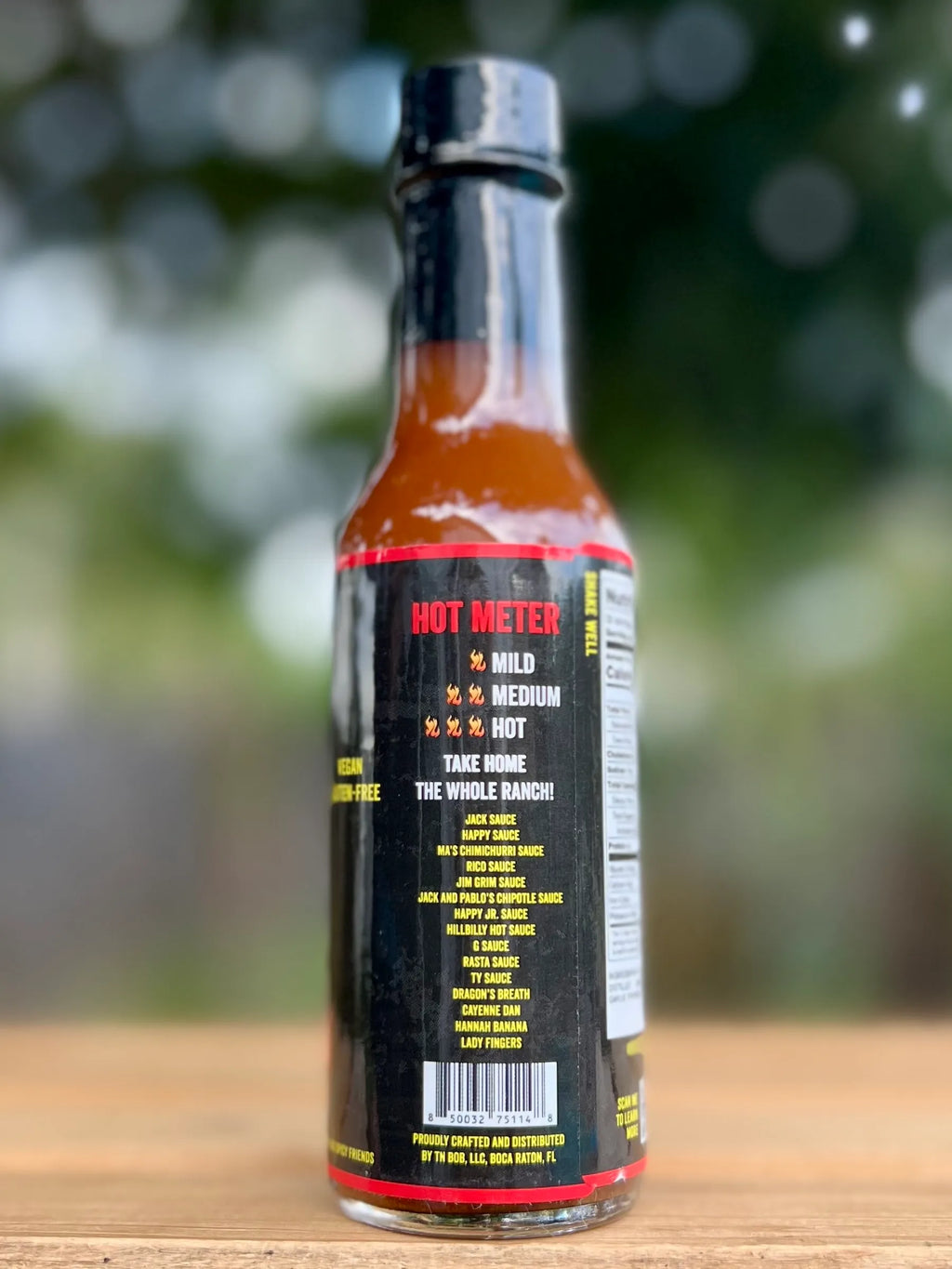 Hot sauce bottle with visible label on a wooden surface
