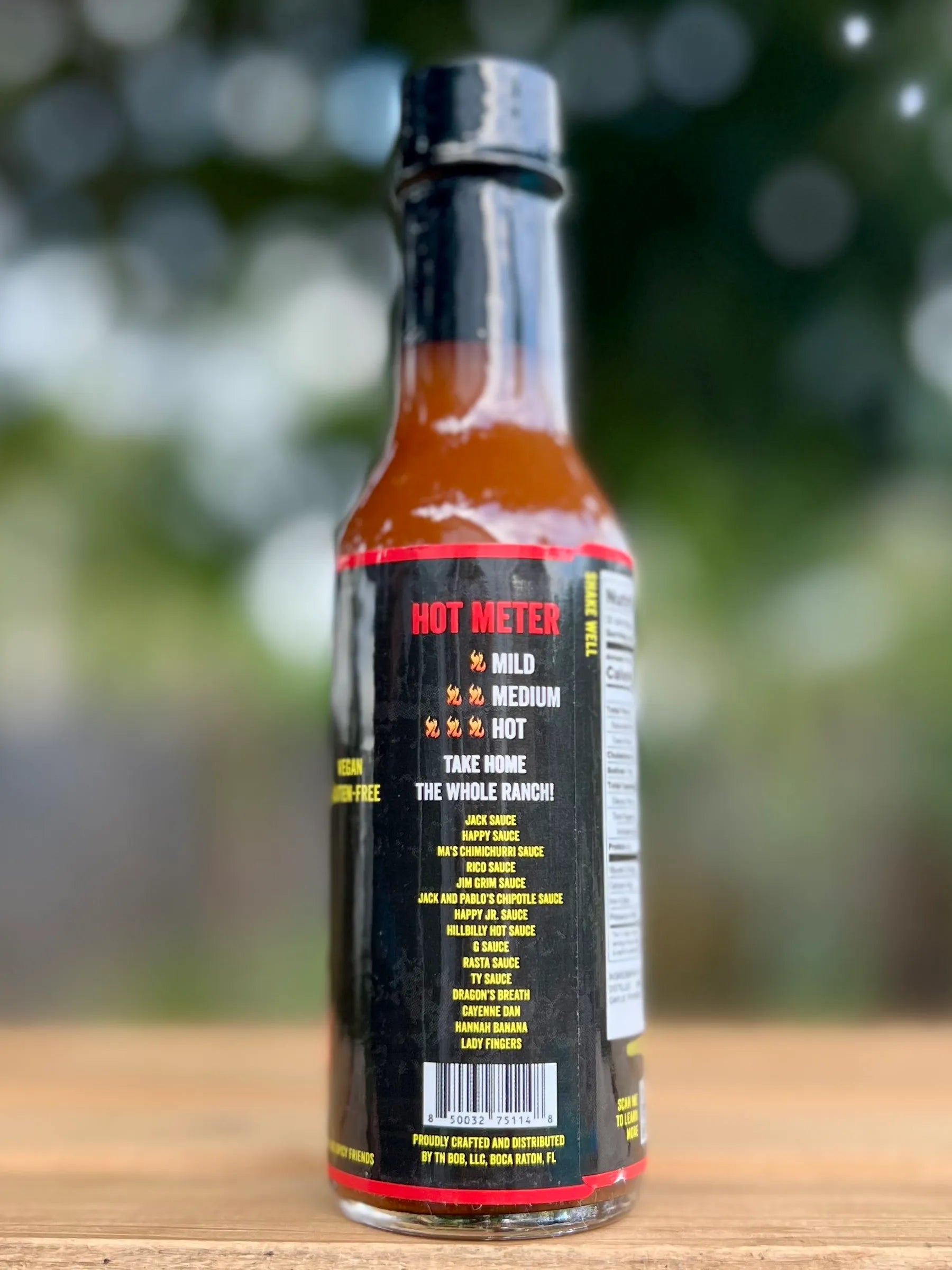 Hot sauce bottle with visible label on a wooden surface