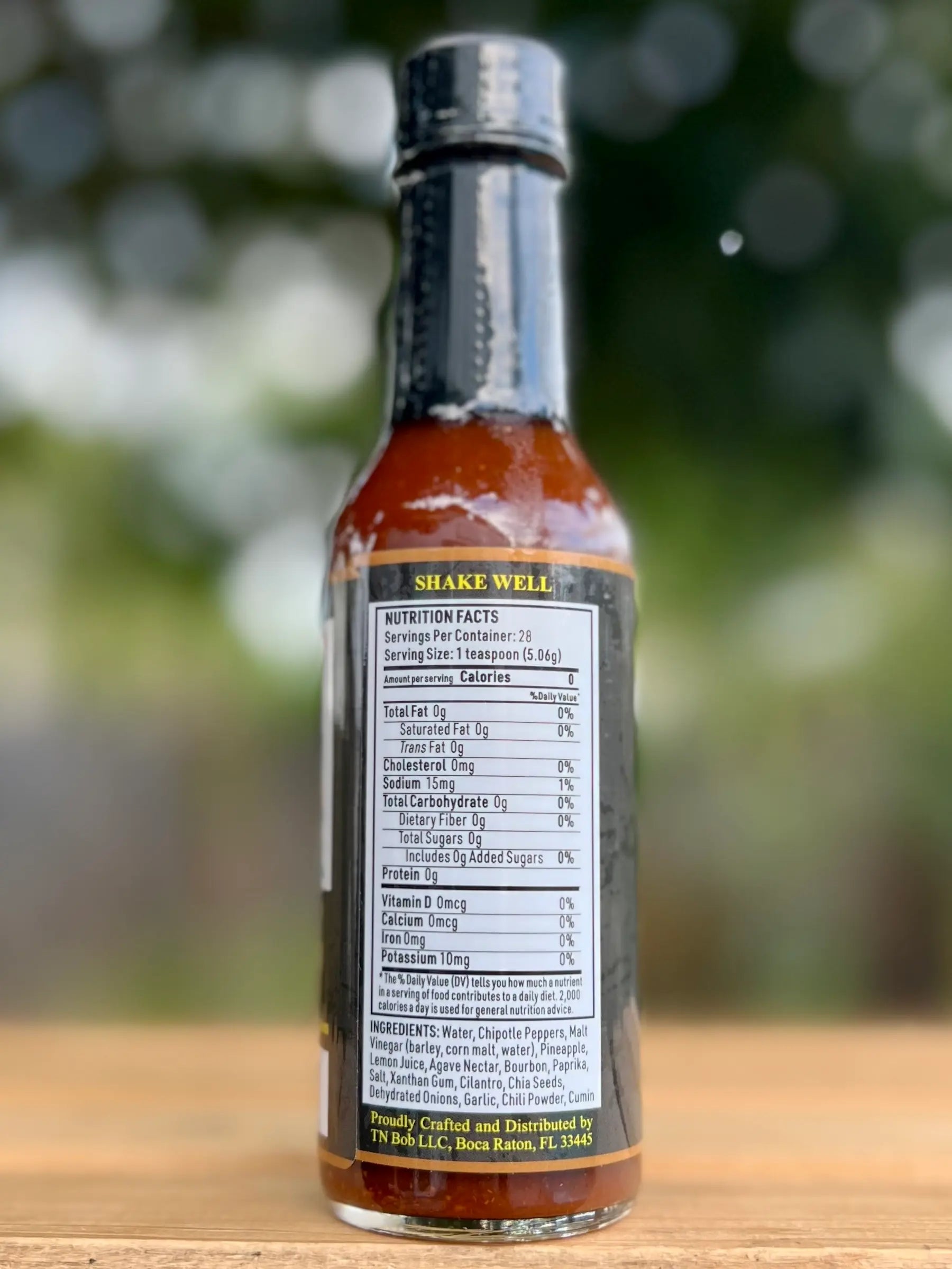Bottle of Chipotle sauce with nutritional information label on a wooden surface