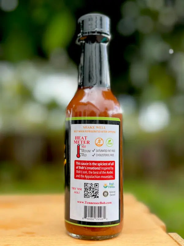 Tennessee hot sauce bottle with heat meter, red label, glass bottle, outdoors background