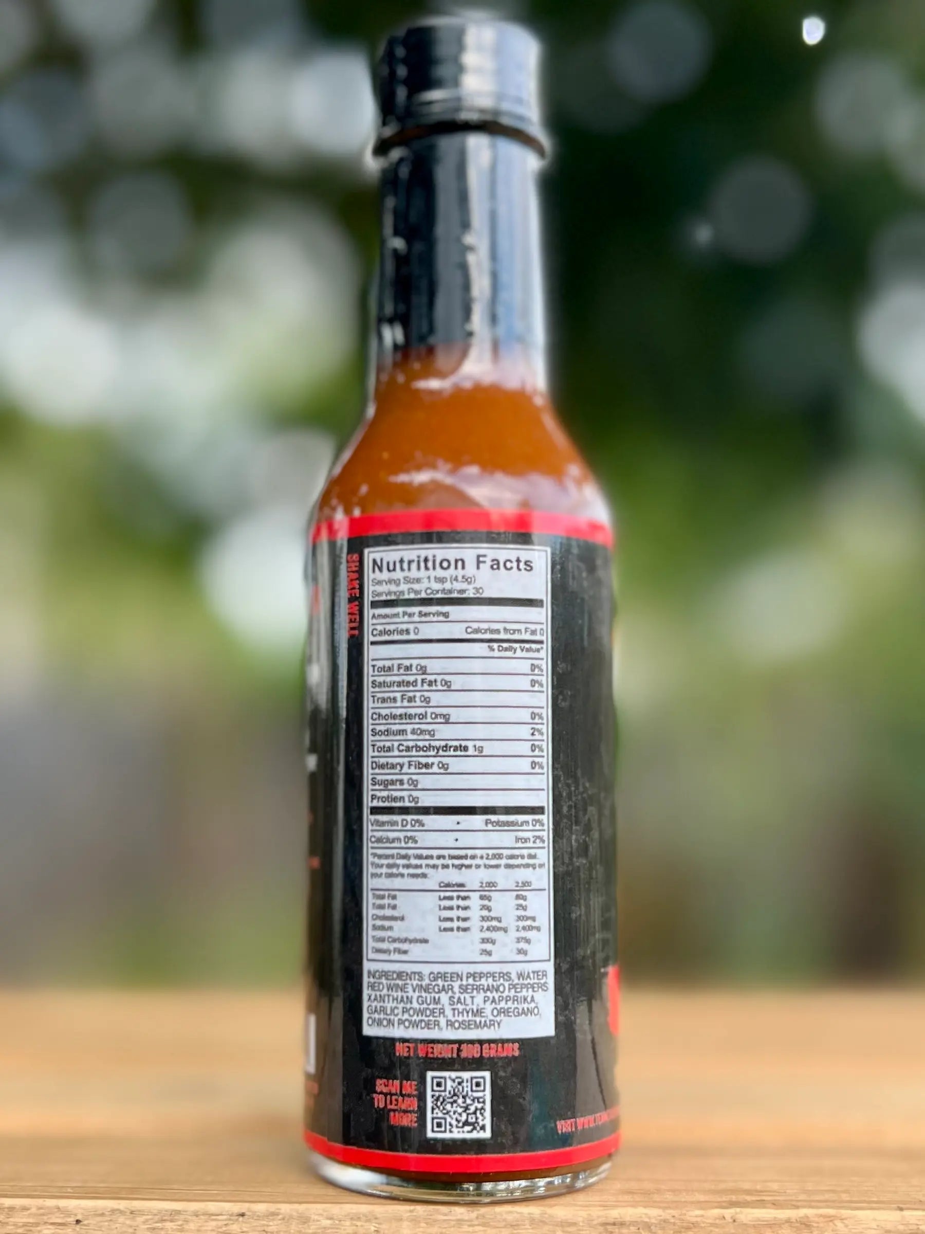 Hot sauce bottle with nutrition facts label on a wooden surface