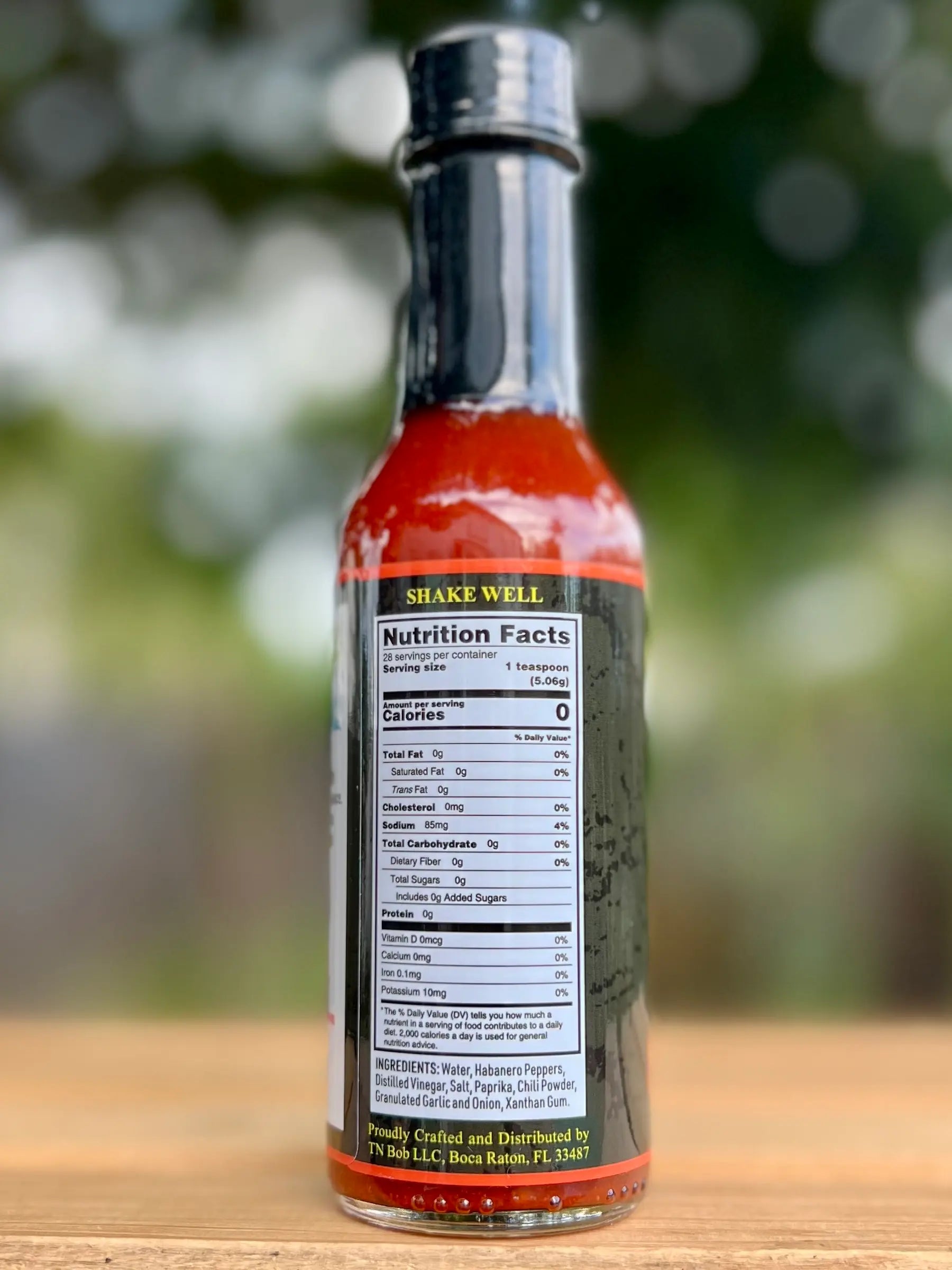 Hot sauce bottle with nutrition label on a wooden surface