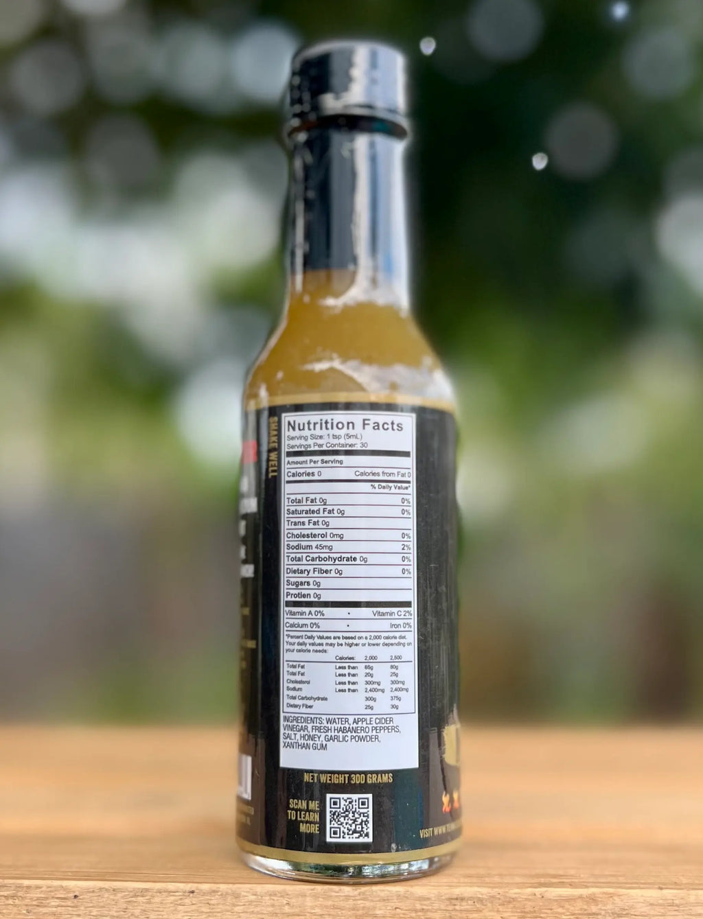 Bottle of sauce with nutrition label on a wooden surface