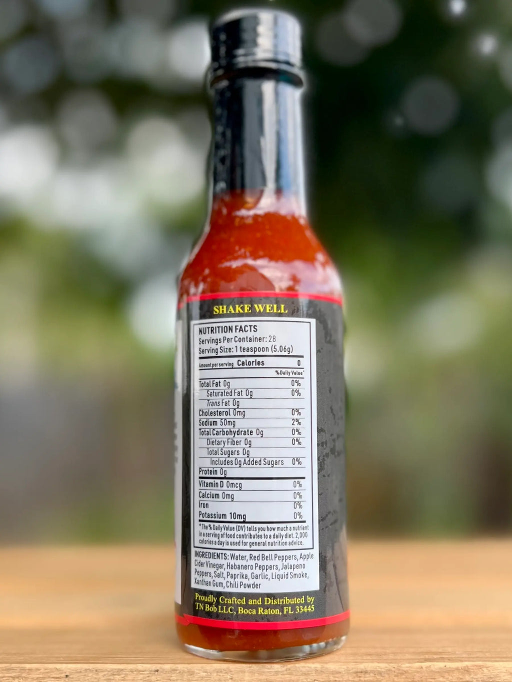 Hillbilly Hot sauce bottle with label on a wooden surface