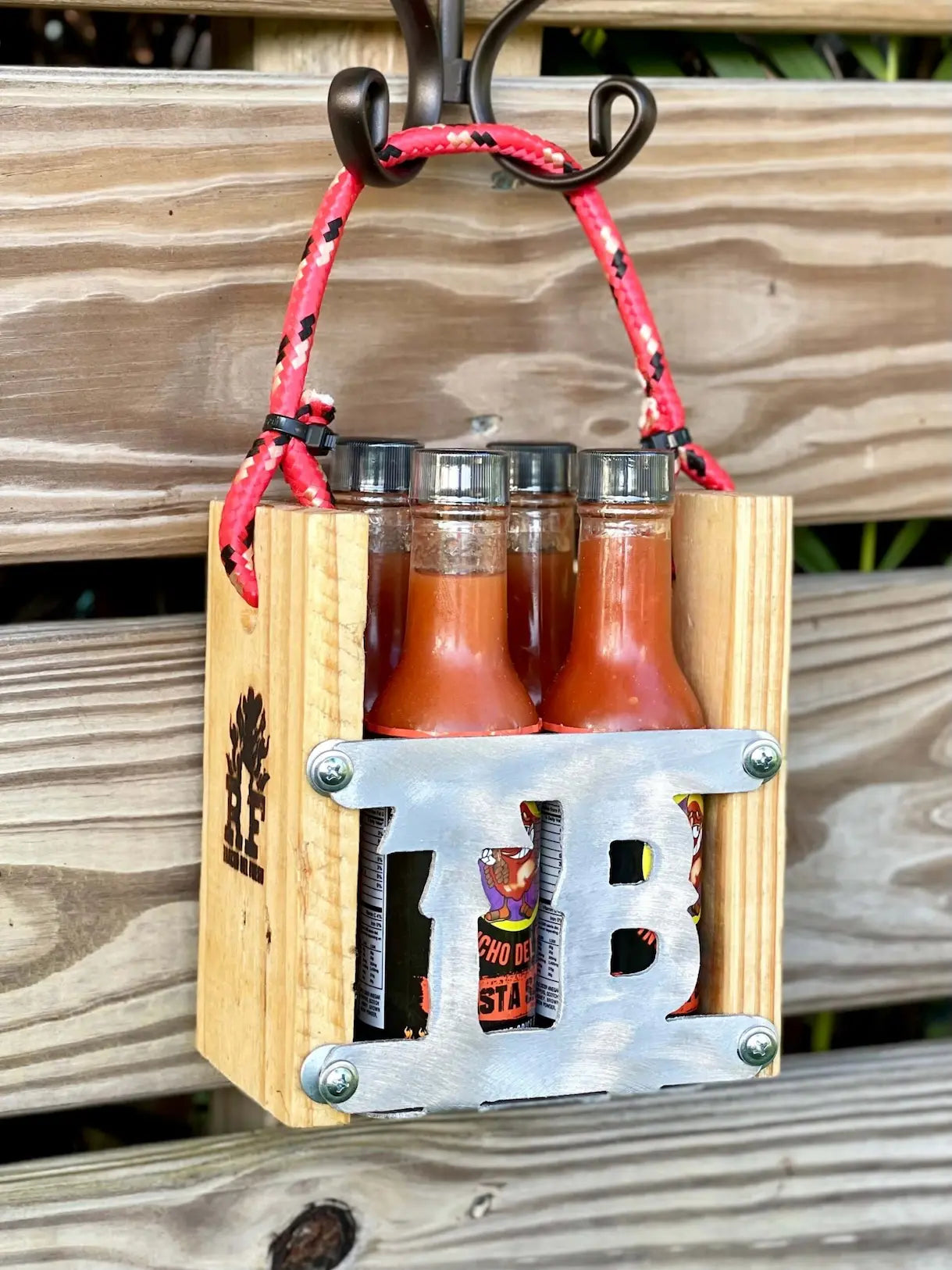Wooden bottle holder with hot sauce bottles on a wooden surface