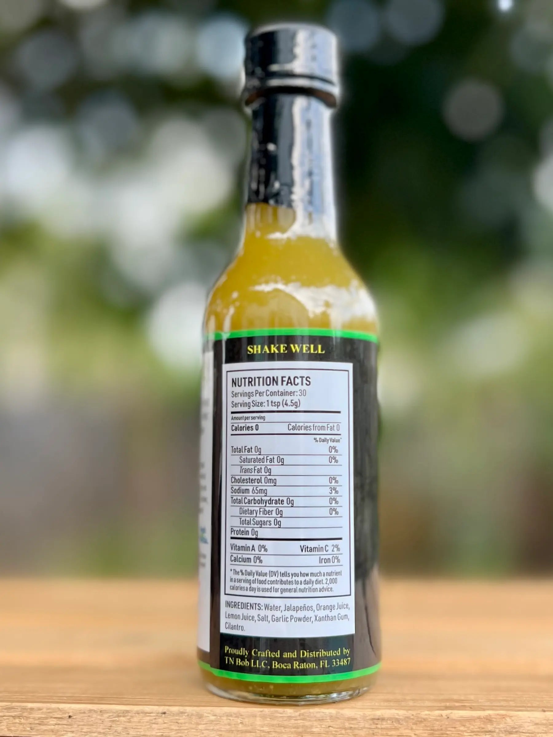 Bottle of Jack Sauce with nutrition facts label on a wooden surface