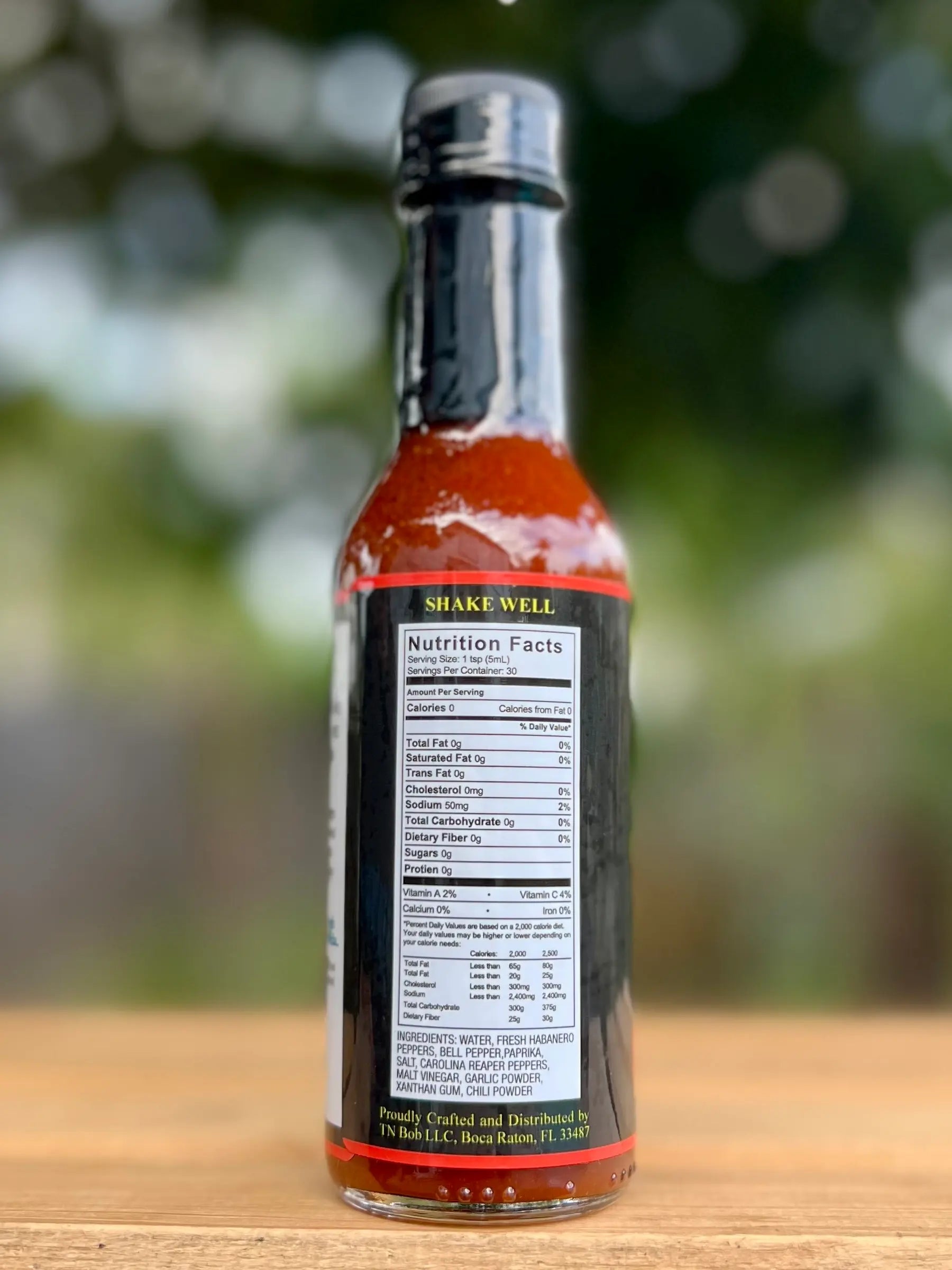 Hot sauce bottle with nutrition label on a wooden surface