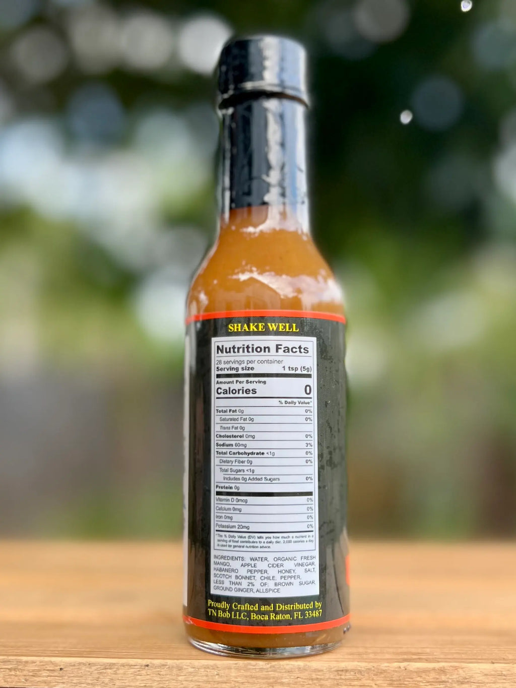 Bottle of Shake Well sauce with nutrition label on a wooden surface