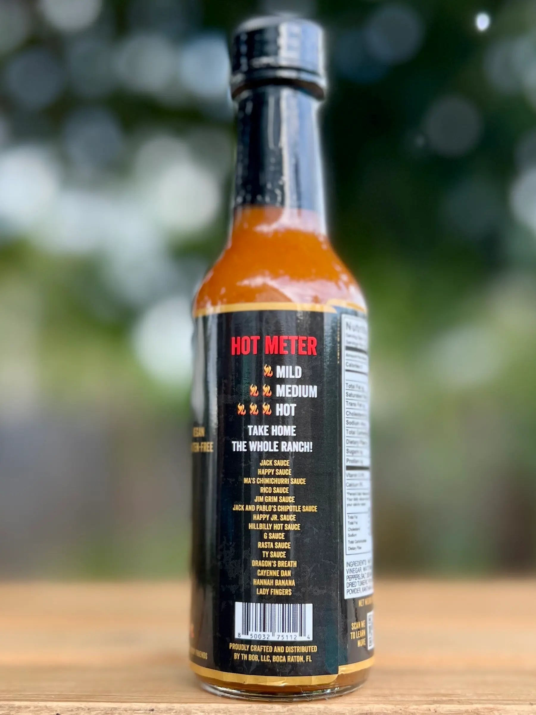 Hot sauce bottle with visible label on a wooden surface