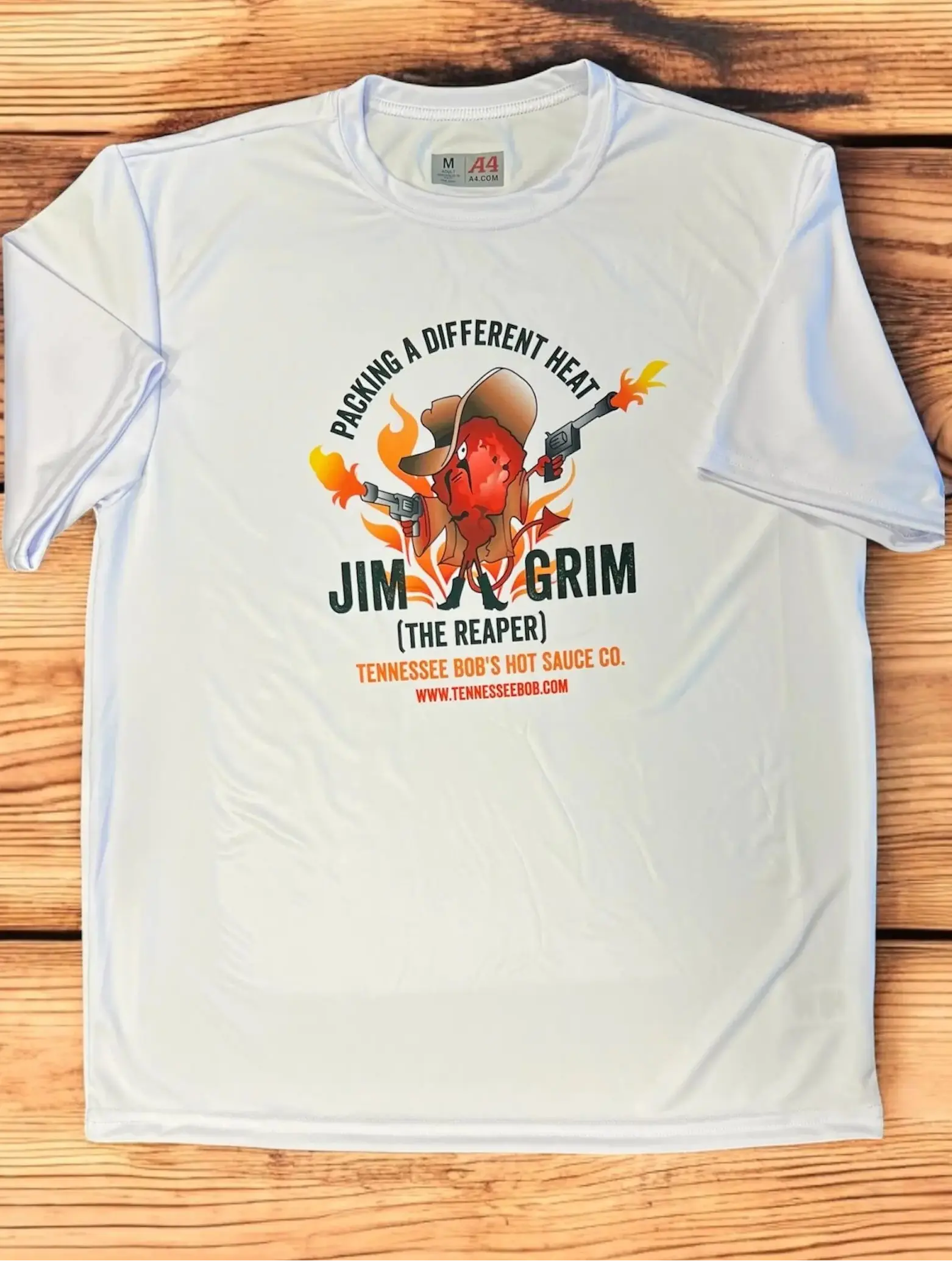 White t-shirt with a cartoon chili pepper character holding guns, featuring "Jim Grim" branding and slogan.
