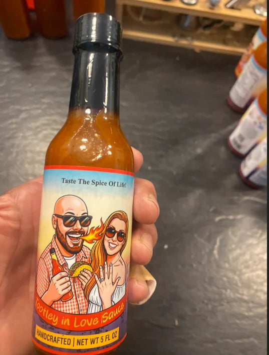 A custom private label hot sauce bottle with the bride and groom illustrated on the label, a wedding favor